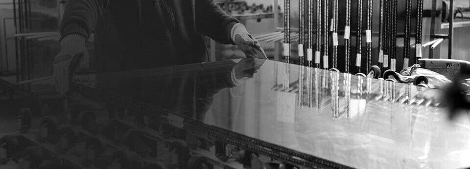 CLSG technician handling a glass panel on the production line
